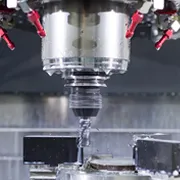 Metallbearbeitung auf einer CNC-Fräsmaschine mit laufendem Fräskopf.